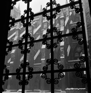 Looking through a wrought iron decorative window grille towards the south facade of the nave of