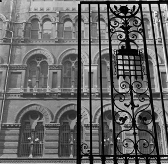 Looking up past the ornate iron gates of Westminster Palace Gardens to the facade of the Army and