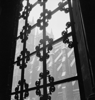 Looking through a wrought iron decorative window grille towards the south facade of the Westminster