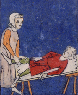 A woman setting a bone in a boy's leg, 14th century. The boy lies back on a table while the woman