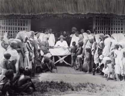 Paying wages to tea estate labourers, Bengal, 1880s. A European distributes pay to Indian workers,
