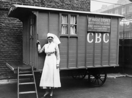 Nurse outside a Marie Stopes mobile birth control clinic, Bethnal Green, London, 1928. 'Free