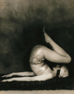 Marguerite Agniel posing with her back arched and feet in the air, wearing a two-piece cos..., 1929. Creator: Unknown.