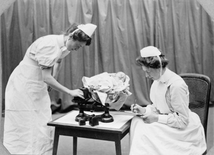 General Lying In Hospital, York Road, Lambeth: nurses weighing a baby, 1908. Creator: Unknown.