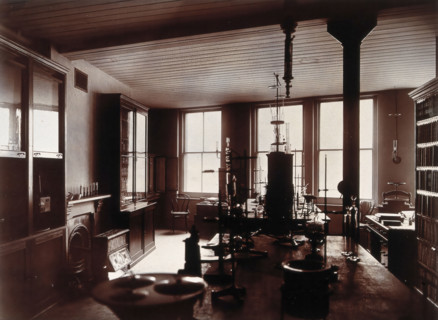 The interior of a pharmaceutical or chemical laboratory, with two long benches in the centre, glass. Creator: Unknown.