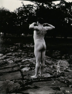 A man posing naked, with his back to the camera, standing on a rocky outcrop, c1900. Creator: Unknown.