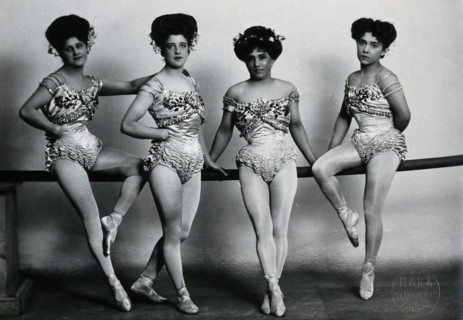 Four young woman acrobats (?), posing on a bar in a photographic studio, between 1899 and 1908. Creator: Unknown.