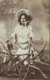 A sailor in drag posed behind a wooden fence, 1906. Creator: Unknown.