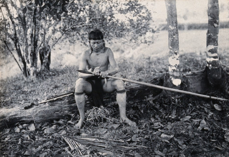 Sarawak: a Kenyah worker tying a spearhead to a blowpipe, c1900. Creator: Unknown.