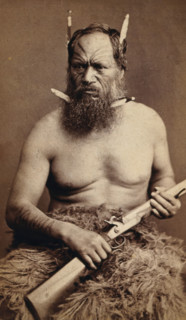 A Maori man with a tattoed face, holding a rifle, c1870s. Creator: James Bragge.
