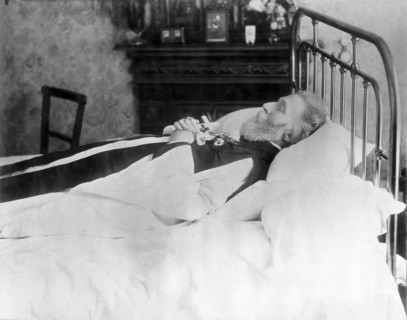 A dead man, wearing robes, lying on his deathbed, (1900?). Creator: Unknown.