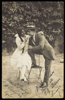 Two actors, one in drag, pose on garden furniture, 1918. Creator: Unknown.