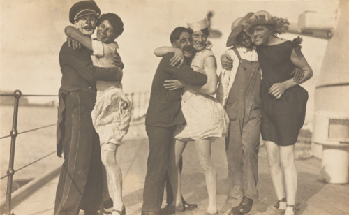 Sailors, some in drag, pose as three couples on the deck of a ship, (between 1920 and 1929?). Creator: Unknown.