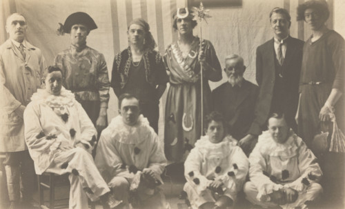 Concert party performers, some in drag, pose for a group portrait, (between 1910 and 1919?). Creator: Unknown.