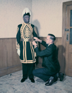 A Paramount Chief being fitted for his robes for the coronation of Queen Elizabeth II, 1953. Creator: Arthur Charles Kirby Ware.