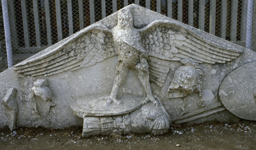 Eagle figure, armour, spear, helmet and circular shield, Roman gable, Side, Turkey, 1999. Creator: LTL.