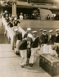 The crew of H.M.S. Hood unload cases at Portsmouth, July 1935.  Creator: Topical Press Agency.