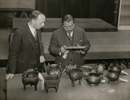 Zheng Tianxin (Dr F. T. Cheng) and Mr F.St. G. Spendlove examining exhibits, 1935. Creator: Topical Press Agency.