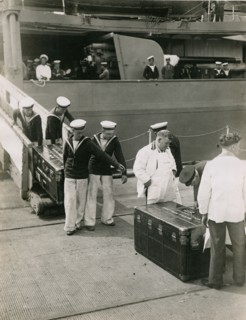Bringing ashore the steel lined cases from the decks of H.M.S. Hood, July 1935. Creator: Topical Press Agency.