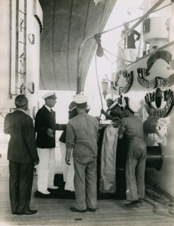Preparing to hoist a case from the deck of  H.M.S. Suffolk at Portsmouth, July 1935. Creator: Topical Press Agency.