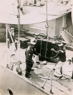 Lifting a case from the deck of  H.M.S. Suffolk at Portsmouth, July 1935. Creator: Topical Press Agency.