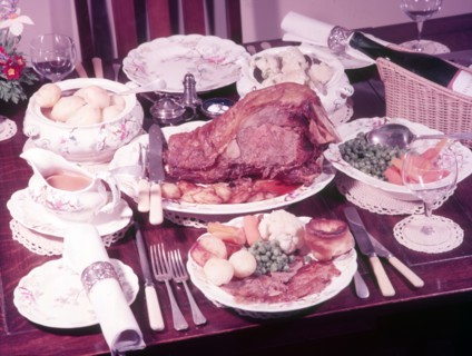 Dining table with roast dinner, c1955. Creator: Arthur Charles Kirby Ware.