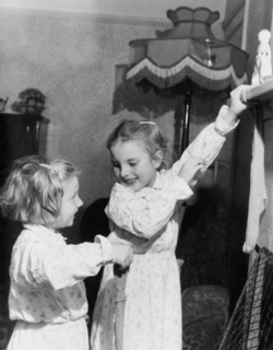 Girls hanging up Christmas stockings, c1955. Creator: Arthur Charles Kirby Ware.