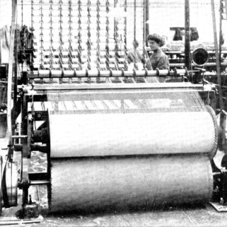 Winding the yarn off the bobbins on to warper's beams, 1909. Creator: Unknown.