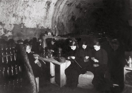 Une famille dans la cave d'une maison de vin de Champagne, à Reims, les femmes tricotent pour les