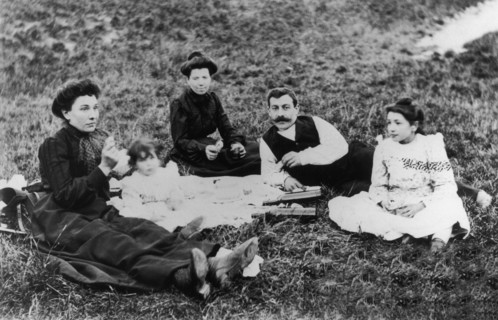 Vers 1900-1910, une famille pique-nique sur l'herbe.