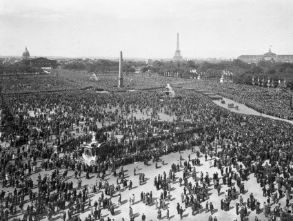 Dans les années 1930 à Paris, foule et défilé militaire du 14 juillet sur la place de la Concorde.