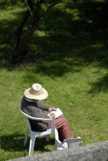 Elderly woman making a drawing in a garden