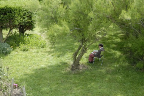 Elderly woman making a drawing in a garden