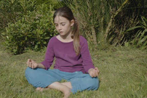 Fillette de 9 ans faisant du yoga dans jardin