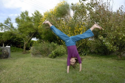 Petite fille faisant la roue dans un jardin