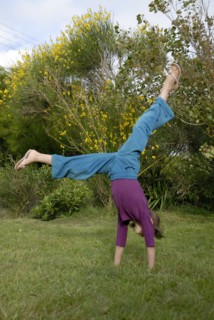 Petite fille faisant la roue dans un jardin