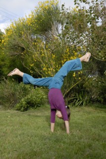 Petite fille faisant la roue dans un jardin