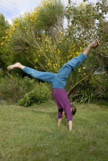 Petite fille faisant la roue dans un jardin