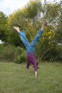 Petite fille faisant la roue dans un jardin