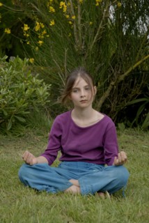 Fillette de 9 ans faisant du yoga dans un jardin