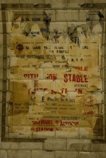 Affiche décollée sur un mur du métro parisien