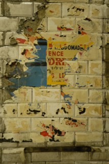 Affiche décollée sur un mur du métro parisien
