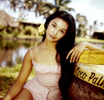 France NUYEN leaning against a boat