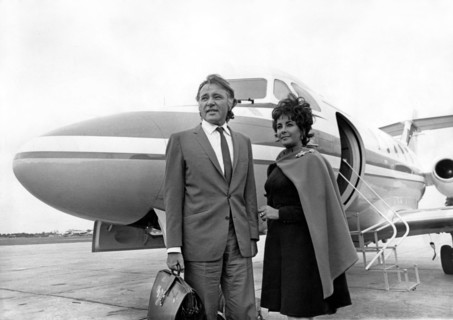 Elizabeth TAYLOR with Richard BURTON in front of plane, 1967