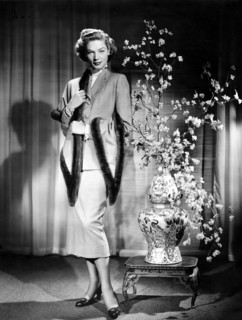 Lauren BACALL, posing next to a vase of flowers