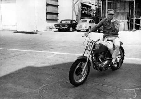 Steve McQUEEN sitting on motorcycle