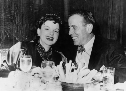 Judy GARLAND and Humphrey BOGART laughing at the dinner table, 1946