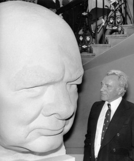 Richard BURTON next to a cement head of Sir Winston Churchill, 1974
