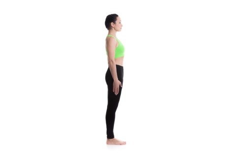 Sporty girl on white background performing basic standing asana tadasana, mountain yoga posture, pose from surya namaskar