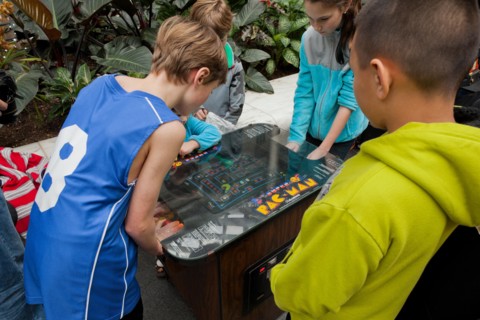 Young children playing the classic Pac-Man video arcade game - USA